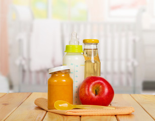 Healthy baby food: milk, juice, puree, apple on  background kitchen.