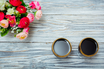two glasses of red wine and flowers
