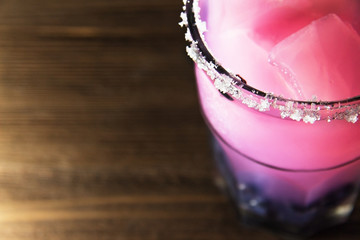 pink jelly in a glass with blueberries on a wooden background