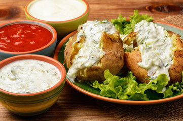Jacket potatoes served with tzatziki sauce.