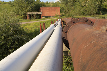 Rusty steel pipelines in grass field
