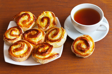 Homemade buns with custard and a cup of tea on the table