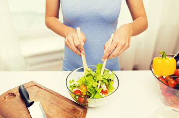 Fototapeta na wymiar close up of woman cooking vegetable salad at home