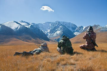 Gordijnen Drie jagers kijken door een verrekijker in de bergen van Tien Sh © okyela