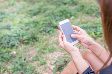 Asian woman with smartphone outdoors in park. Closeup of female hand