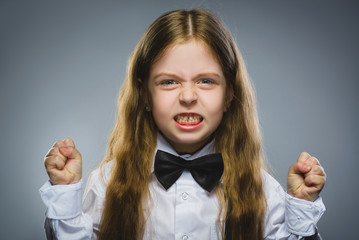 Portrait of angry girl with hand up yelling isolated on gray background. Negative human emotion,...