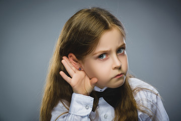 Curious Disappointed girl listens. Closeup portrait child hearing something, parents talk, hand to...
