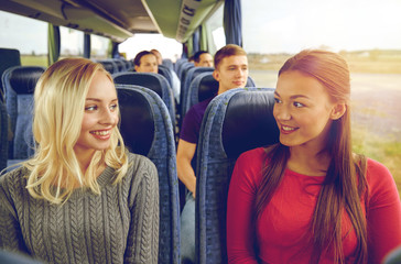 happy young women talking in travel bus