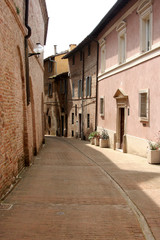 Fototapeta na wymiar Lane in Urbino, with small street and little buildings of red bricks, Italy