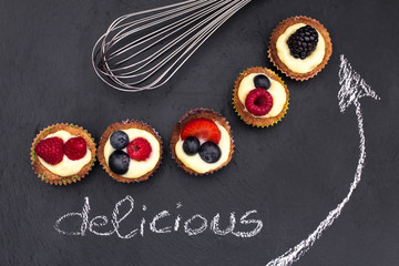 creative set with mini pastry and whisk over slate