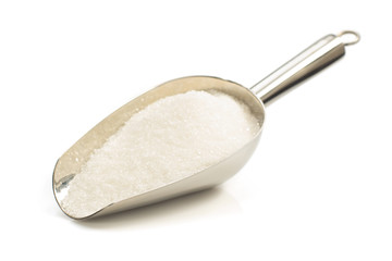 granulated sugar in scoop on white