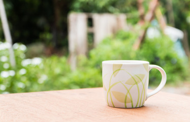 a cup of coffee and books on the wooden table