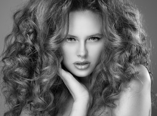 Young beautiful woman with long curly hairs and professional mak