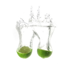 Limes splash on water, isolated on white background. Fresh drinks advertisment