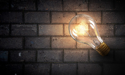 Light bulb on brick surface