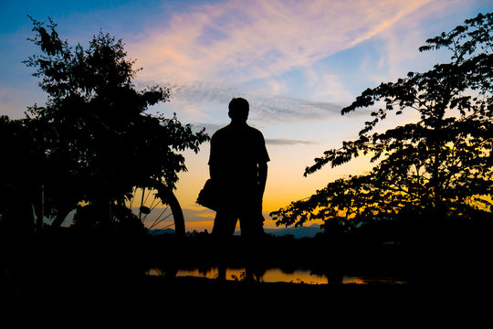 silhouette Middle-aged man  exercise by bicycle in twilight time