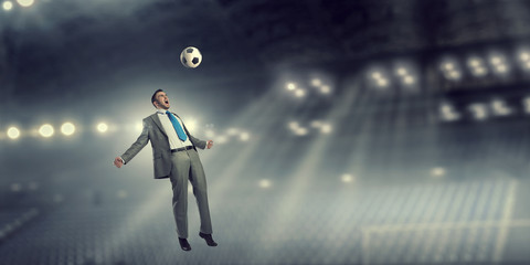 Businessman kicking ball