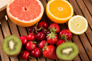 Naklejka na ściany i meble Fresh fruits on color on wooden background