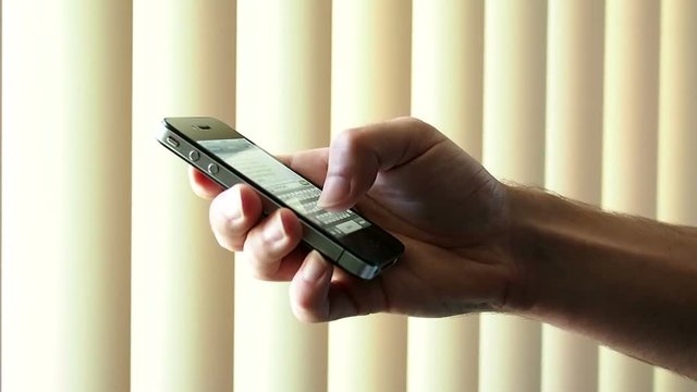 Male hand texting on a iPhone smartphone