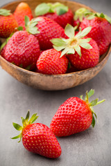 Strawberry in a bowl on the gray background.