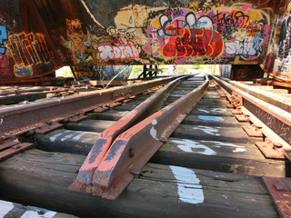 Vintage old weathered rusty metal train tracks with urban graffiti