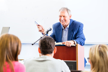 Studenten hören Universität Professor bei einem Vortrag am Rednerpult zu