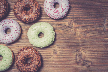 Colorful donuts on wooden table