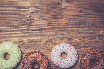 Colorful donuts on wooden table