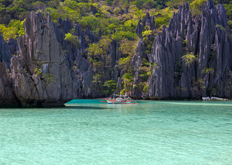 Landscape with philippino boat, rocks and blue bay. El Nido,  Palawan