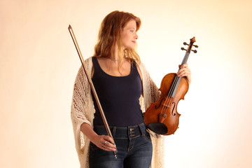 Eine Frau mit Geige und Geigenbogen in den Händen