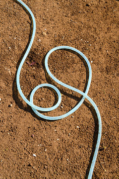 garden hose, dry soil background