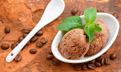 Coffee ice cream with mint leaves in a white Cup