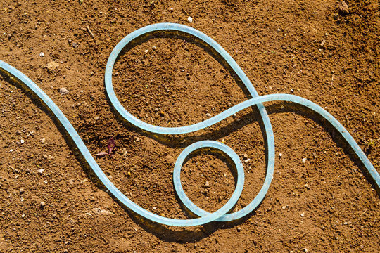 garden hose, dry soil background