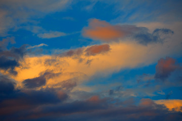 Naklejka na ściany i meble Sunset orange clouds in a blue sky