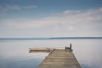 Lake peer with wooden bench with beautiful sky clouds on sunset travel vacation. Print on canvas