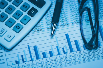 Accounting financial bank banking account stock spreadsheet data with glasses pen and calculator in blue financial concept