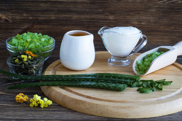 Natural cosmetic ingredients. Aloe vera, oil, sea salt, handmade cream on a wooden board. Spa concept.