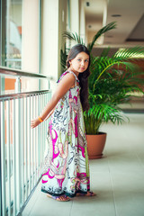 Beautiful little girl in dress standing in a hotel
