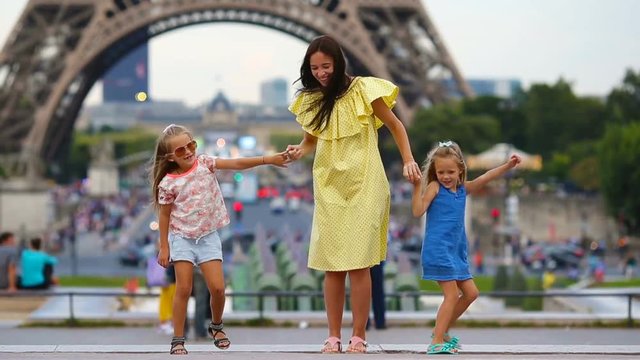 Happy family in Paris near Eiffel tower. French summer holidays, travel and people concept.