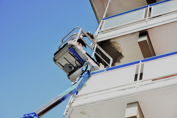 Un artigiano, ripara il balcone di una palazzina.