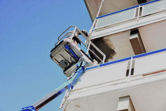 Un artigiano, ripara il balcone di una palazzina.