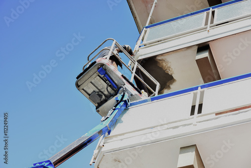 Un artigiano, ripara il balcone di una palazzina.
