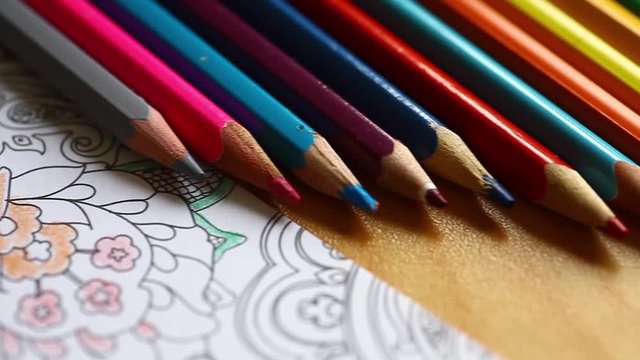 Sliding video of some pencils and an adult coloring book.