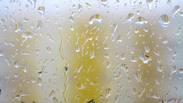 Color footage of some raindrops on a window.