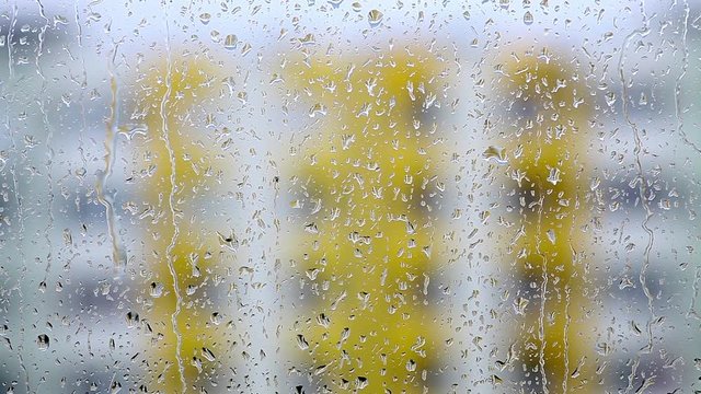 Color footage of some raindrops on a window.