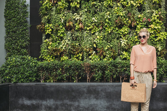 Woman next to foliage wall