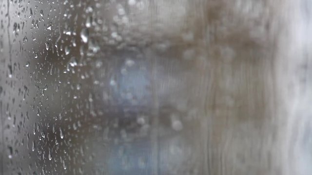 Color footage of some raindrops on a window, with focus transition