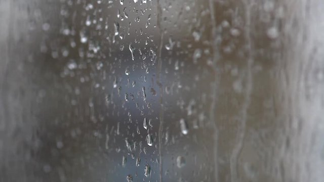 Color footage of some raindrops on a window, with focus transition.