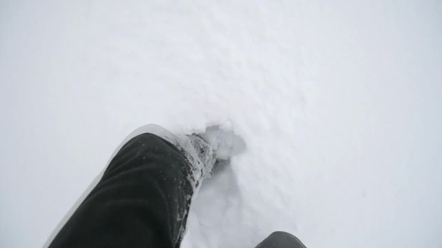 Point of view of feets walking on snow.