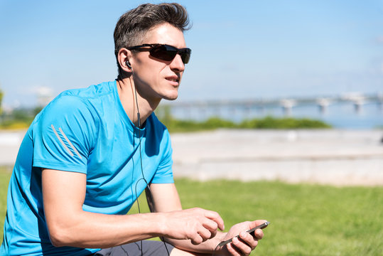 Sporty guy listening to music while training 